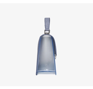 Detail of transparent PVC handbag showing blue and white twill fabric handle and silver hardware