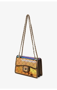 Macro detail of iridescent PVC crossbody bag with diamond quilted pattern and golden chain