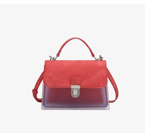 Detalle de solapa de cuero rojo y cierre de metal plateado en bolso de PVC jelly