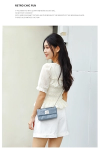 Detail of blue-grey leather crossbody bag with silver chain strap and retro metal lock