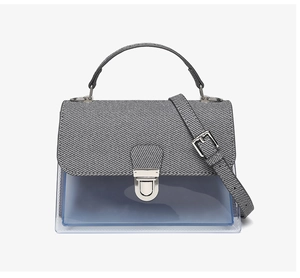Detail of grey twill fabric and transparent blue PVC messenger bag with silver lock