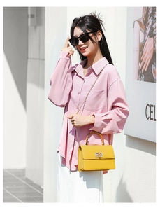 Detalle de bolso amarillo con asa de bambú y cadena dorada en una toma de estilo urbano