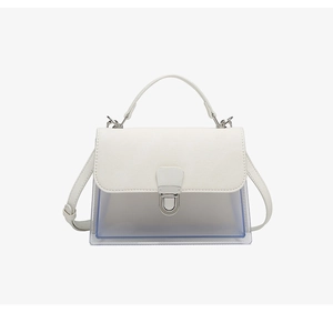 Detalle del bolso bandolera de cuero blanco y PVC azul transparente con hebilla de plata