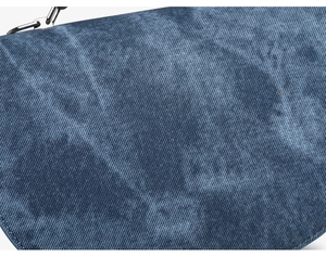 Detalle del bolso bandolera de mezclilla azul con textura de sarga y cadena de plata