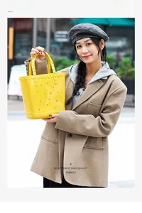 Detail view of yellow PVC tote bag with star patterns and stylish stud textures