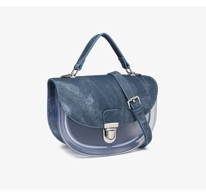 Detalle de la solapa de mezclilla azul y el cuerpo de PVC transparente del bolso