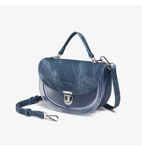 Detalle del bolso de silla en denim azul y PVC transparente con hebilla de metal plateado