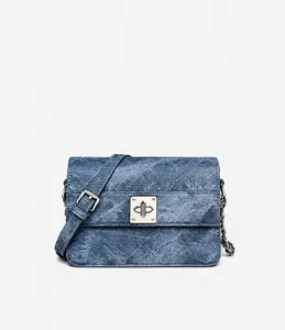 Detailansicht der blauen Denim-Umhängetasche mit silbernem Schloss und Kettenriemen