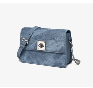 Dettaglio della borsa a tracolla in denim blu con trapuntatura a rombi e chiusura argento