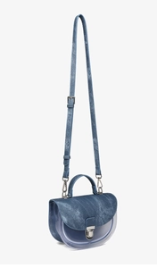 Detalle de mezcla de tela vaquera azul y PVC transparente en bolso silla con hebilla plata