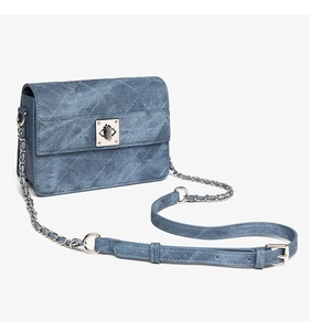 Dettaglio borsa a tracolla in denim blu con chiusura rotante argento e trapuntatura