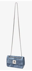 Detail of blue denim crossbody bag featuring silver chain strap and metal turn-lock closure