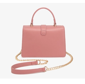 Detalle de bolso en cuero PU rosa con correa de cadena dorada y cierre en forma de corazón