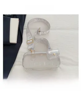 Detail der transparenten PVC-Handtasche mit Logoprägung und breitem Textilriemen