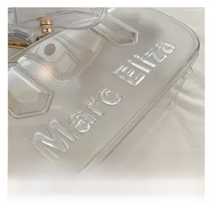 Detail der pinkfarbenen PVC-Tasche mit Marc Eliza Reliefprägung und goldener Schnalle