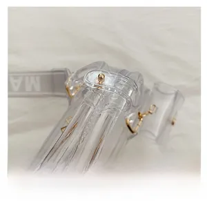 Detailaufnahme der klaren PVC-Handtasche mit Doppelrohrgriffen und Gold-Metallnieten