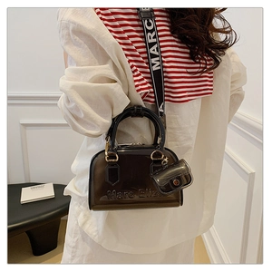 Dettaglio borsa jelly in PVC nero traslucido con testo a rilievo e ampia tracolla
