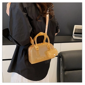 Dettaglio ravvicinato di una borsa jelly color caramello in PVC con tracolla in tessuto