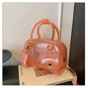 Dettaglio della borsa jelly in PVC arancione con testo a rilievo e tracolla larga