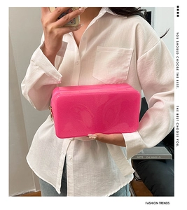 Detail of pink translucent waterproof cosmetic bag with glitter and gold zipper accents