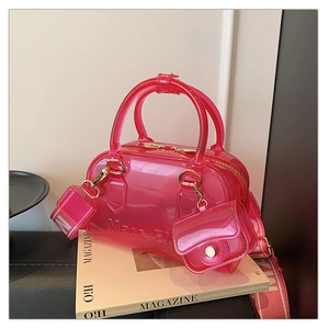 Dettaglio della borsa in PVC rosa trasparente con goffratura e ampia tracolla jacquard
