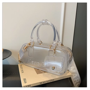 Detail der durchsichtigen grauen PVC Tasche mit goldener Hardware und Webgurtband