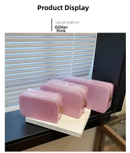 Close-up of three pink glitter PVC makeup bags with golden heart-shaped zipper pulls