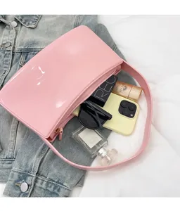 Bolso rosa brillante de hombro mostrando su gran capacidad interna para objetos