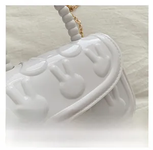 Close-up of white rabbit relief jelly bag with bead handle and gold chain detail