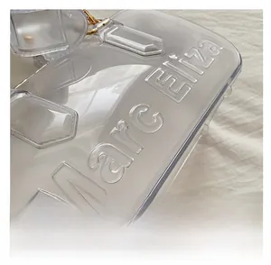 Macro detail of the embossed Marc Eliza logo on a transparent PVC pillow bag surface