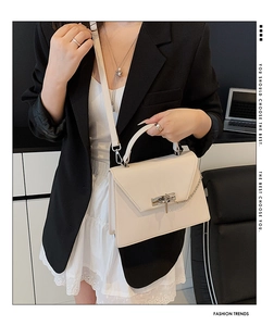 Détail d'un sac élégant en cuir blanc cassé avec boucle en métal et bandoulière chaîne argent