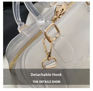 Detail of light gold spring hook and metal D-ring on a clear PVC transparent bag
