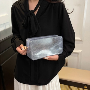 Transparent sequin cosmetic bag with a zipper, held by a model for a stylish look