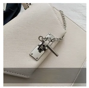 Détail du sac à main en cuir texturé blanc cassé avec fermoir rotatif argenté et chaîne