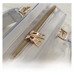Macro shot of high-transparency PVC jelly bag with gold dual zippers and metal hardware