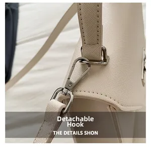 Détail d'un sac bandoulière crème avec crochet métallique argenté amovible et sangle