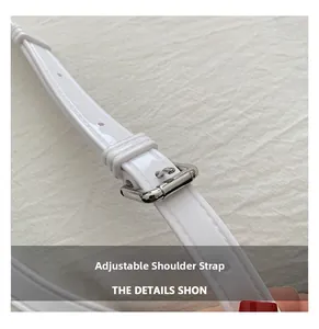 Close-up of adjustable white leather shoulder strap with polished silver metal buckle