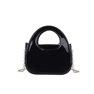 Modern minimalist black glossy evening bag with circular handle and gold chain strap