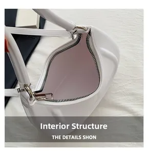Macro detail of the interior compartment and metal zipper closure of white crescent bag