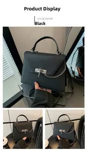 Vue détaillée du sac à main en cuir noir grainé avec fermoir en croix argenté et chaîne