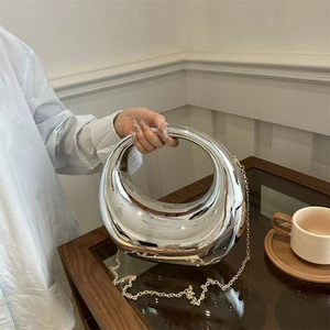 Détail du sac demi-lune argenté métallisé avec poignée creuse circulaire et chaîne dorée
