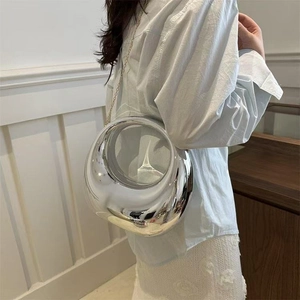 Détail du sac boule en acrylique argenté avec fenêtre ronde et chaîne dorée