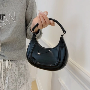 Minimalist black patent leather crescent moon hobo bag with polished silver zipper detail