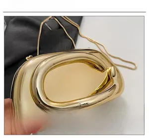 Macro detail of glossy gold metallic evening clutch with sleek streamlined oval design