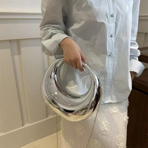 Détail du sac à main miroir argenté avec poignée ronde et bandoulière chaîne dorée