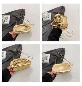 Detail of gold metallic clutch with geometric handle and chain strap for evening wear