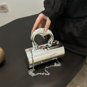 Silver cylindrical handbag with heart-shaped metal handle and chain strap for women
