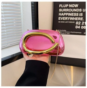 Pink acrylic evening clutch bag with large golden C-shaped handle and chain strap