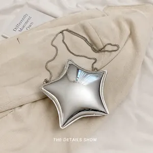 Vista macro del mini bolso plateado en forma de estrella con acabado metálico y cadena