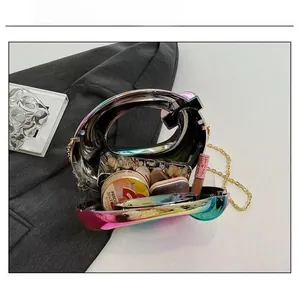 Detail view of colorful acrylic Q-shaped handbag showing interior capacity for makeup